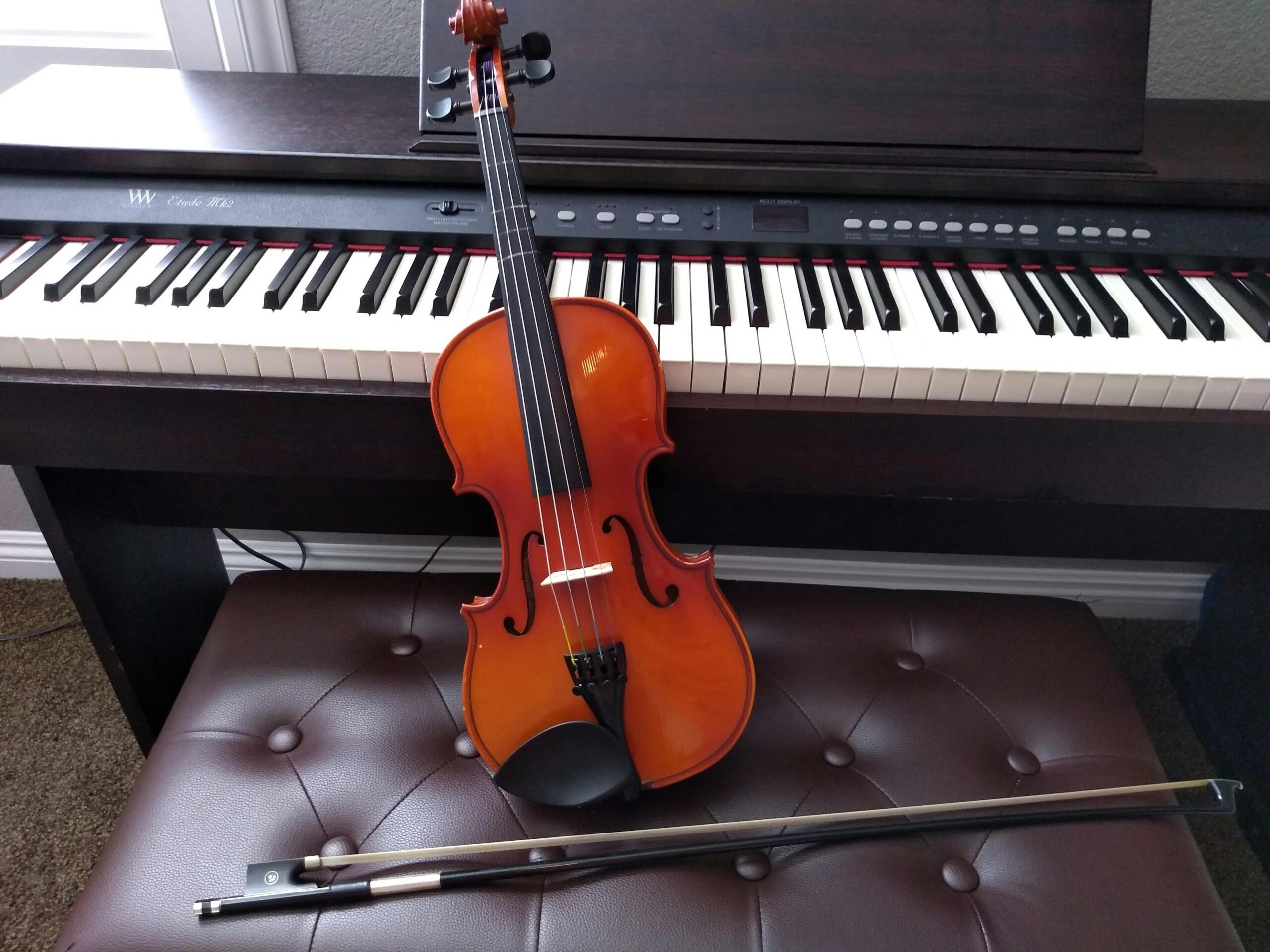 The Benefits of Learning Musical Instruments 1 brown violin with brown violin bow beside white electronic keyboard